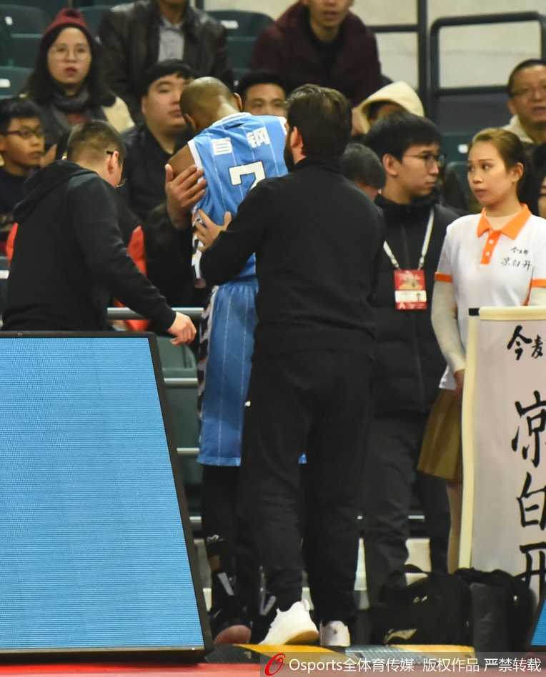 队医在更衣室通道紧急检查杰克逊的伤势，周围人员神情紧张而关切