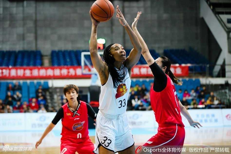 北京女篮球员在四川队严密的防守缝隙间，如同利刃出鞘般持球强行突破，眼神中充满了对胜利的渴望。