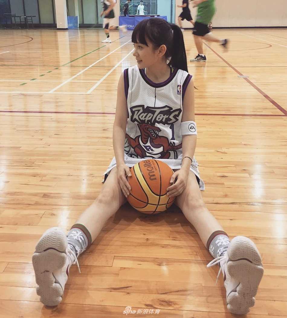 洗菜坐在场边休息，阳光下的笑容依旧灿烂，展现了篮球女孩的元气与纯真。