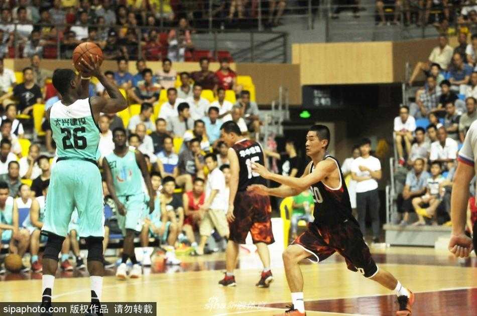 一位非洲球员在武鸣的赛场上接到队友传球后，面对防守果断起跳投篮，他身后的看台上挤满了密密麻麻的观众，每个人的目光都紧紧追随着这颗飞旋的篮球。