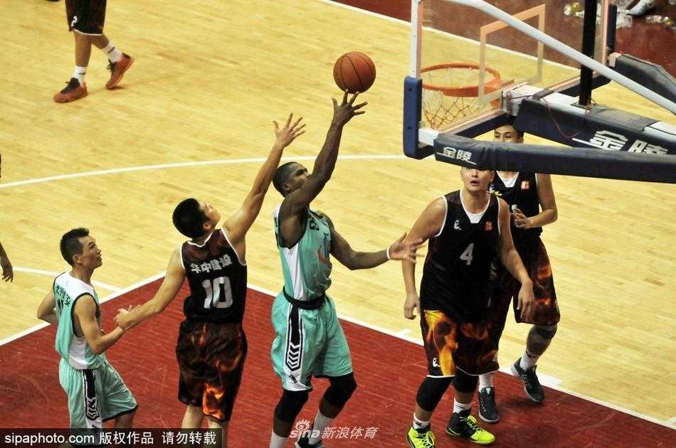 武鸣区篮球联赛的赛场上，一名外籍球员高高跃起，在空中与对手进行激烈拼抢，他手臂上隆起的肌肉线条，彰显着力量与竞技体育的美感。