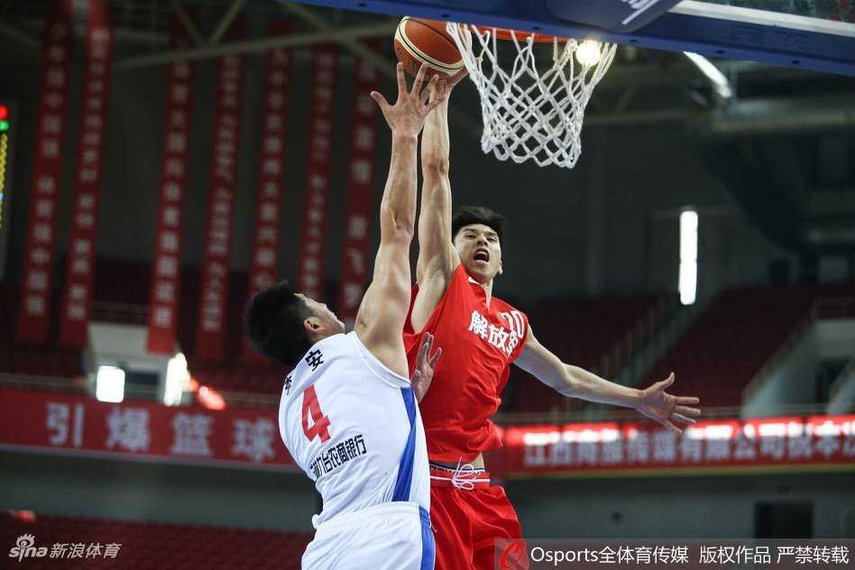 解放军队球员快攻中持球突破，眼前一片开阔地，他双腿发力高高跃起，双手将球举过头顶，准备以一记雷霆万钧的扣篮终结这次进攻。