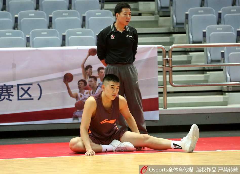 训练间隙，王治郅亲自捡起滚落到场边的篮球，准备为年轻队员们进行一对一的内线脚步示范，场边的队友们都在期待这次教学。