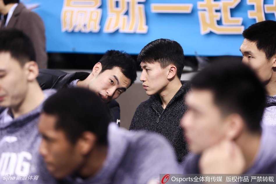 刘晓宇坐在场边替补席，身穿便服双手托腮，专注地看着场内，眉宇间流露出一丝焦急与渴望。