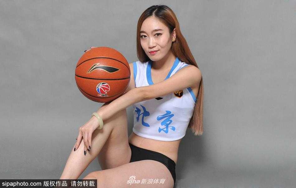 篮球宝贝身穿北京男篮白色球衣，在运动场看台上回眸一笑，青春气息扑面而来