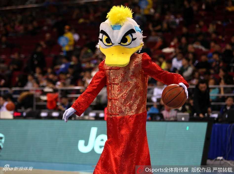 北京篮球圣地春节红 霹雳鸭盛装助力首钢挺进季后赛 霹雳鸭套上了肥大的财神爷戏服,脸上贴着大胡子,手里捧着一个巨大的金色元宝,在场地中央扭动身体,仿佛在向四周抛洒着财运与福气。