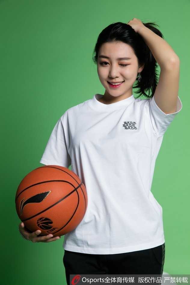 双手轻轻比出爱心手势置于眼前，女孩闭上一只眼俏皮瞄准，仿佛在用这个甜蜜的姿势向镜头那端的球迷发射一颗无形的“爱心子弹”，古灵精怪的模样令人忍俊不禁。