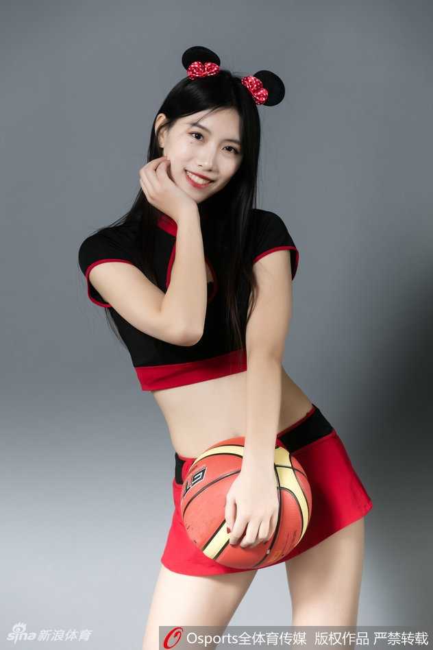 北控篮球宝贝米奇装扮萌翻赛场 青春热舞点燃冬日激情 一位篮球宝贝侧身回眸,乌黑的长发上戴着精致的米奇耳朵发卡,眼神俏皮灵动,背景是模糊的看台人浪