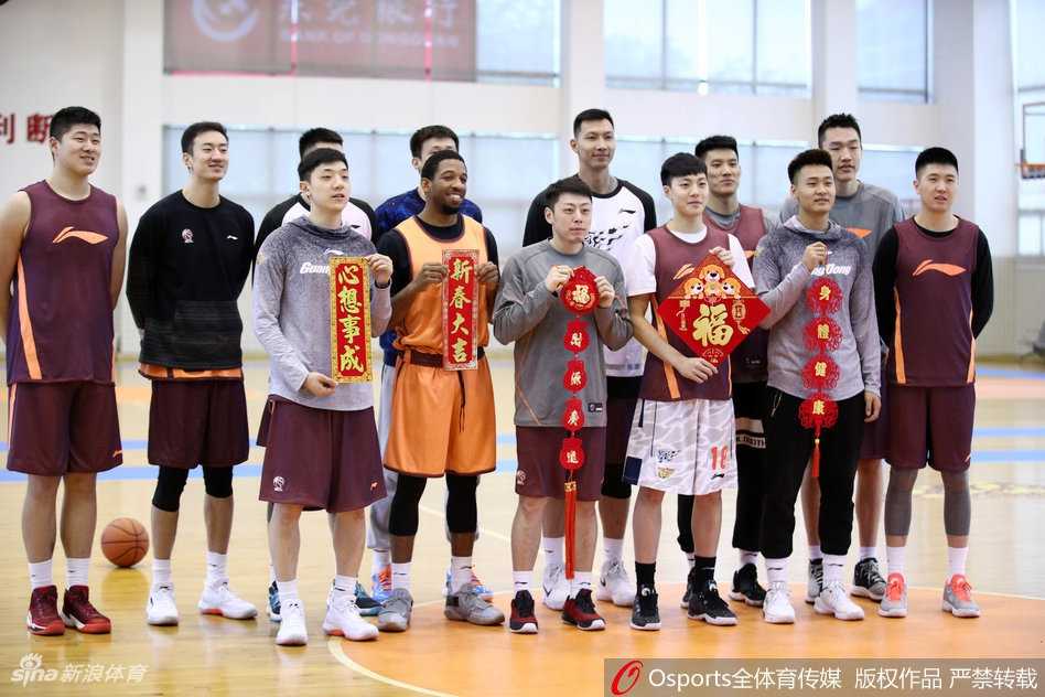 全队在喜庆背景前的全家福大合影，每个人手中都展示着带有俱乐部元素的红色围巾，象征着团结一心，共同迎接新春挑战。