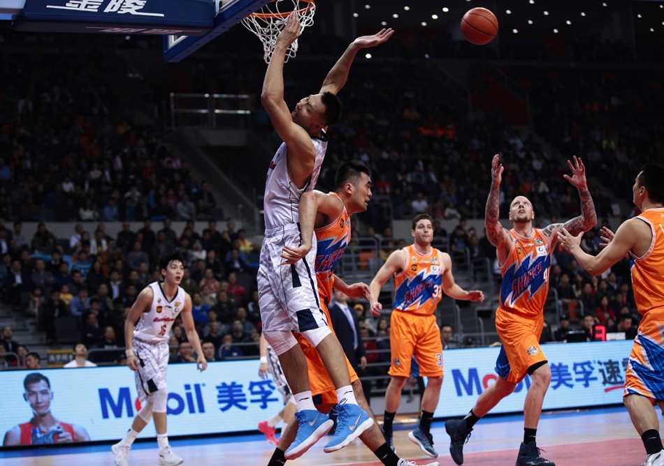 易建联在对手的严密防守下依然冷静出手，篮球在空中划出完美弧线