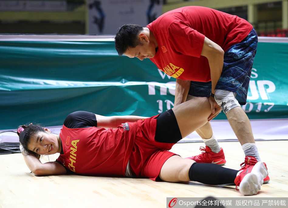 印度备战显从容女篮队员展轻松心态 球馆角落,一位印度女保安微笑着注视正在收拾装备的中国女篮队员,队员们则神态自若地整理衣物,气氛安静而融洽。