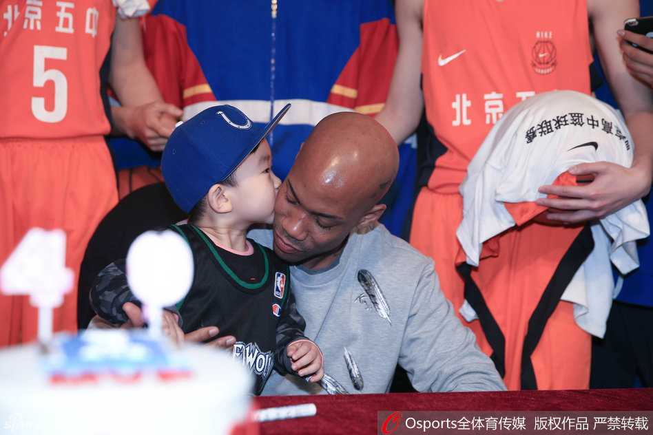 四十不惑再出发:马布里生日会上泪别失意,誓言为京城球迷再战一年 一位身穿马布里森林狼队复古球衣的小球迷被老马宠溺地抱在怀中,小家伙开心地亲吻老马的脸颊,老马则满脸享受,眼神中透出父亲般的温柔。