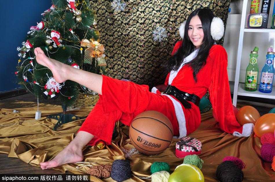 身穿红裙的篮球宝贝在飘落的雪花道具中轻盈转身，定格下如梦似幻的圣诞瞬间