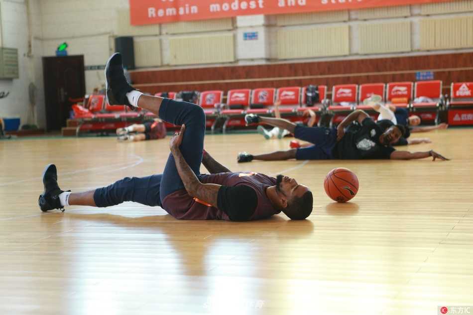 新疆飞虎众将齐聚训练馆，队长可兰白克神情专注聆听训话，卫冕冠军的沉稳与杀气在空气中弥漫。