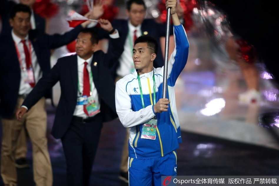 天津全运耀津门 亚洲第一控卫郭艾伦擎旗辽篮 聚光灯下的郭艾伦,身姿挺拔,面带微笑,挥舞旗帜的动作潇洒而有力。