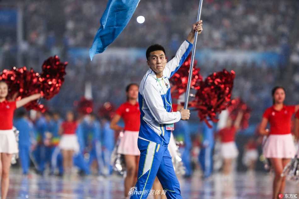 天津全运耀津门 亚洲第一控卫郭艾伦擎旗辽篮 郭艾伦高举辽宁代表团大旗,步入天津全运会开幕式现场,眼神中充满坚定与自豪。
