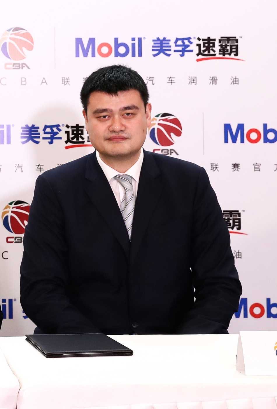 姚明在话筒前发表致辞，身后的背景板印着双方品牌标识，他沉稳自信的神态让在场者对CBA的未来充满信心。