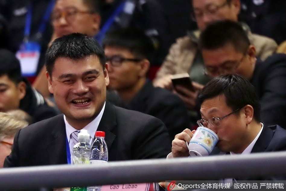 姚明现身督战新馆启航,男篮红队残阵轻取香港取世预赛开门红 篮协主席姚明身着一件深色长款大衣,神情专注地站在场边观战,目光深邃而充满期待,仿佛在审视着红队这些年轻人的每一滴汗水与成长。