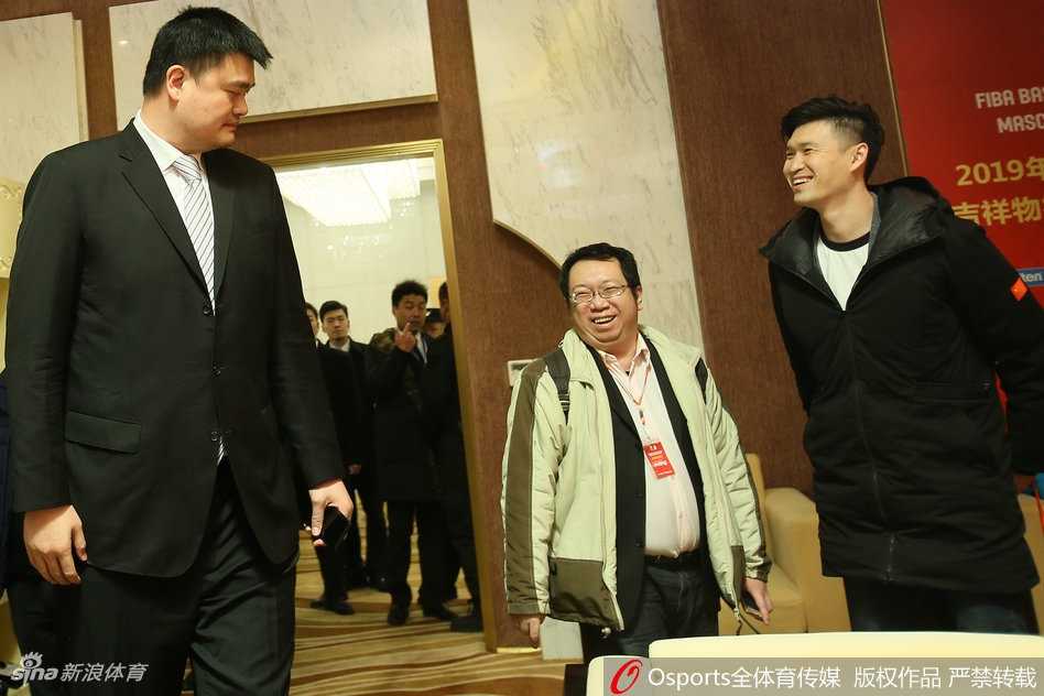 仪式现场的姚明目光炯炯，神情专注地审视着舞台上的动态，高大身影在聚光灯下显得格外引人注目，仿佛一座移动的长城守护着中国篮球的荣誉。