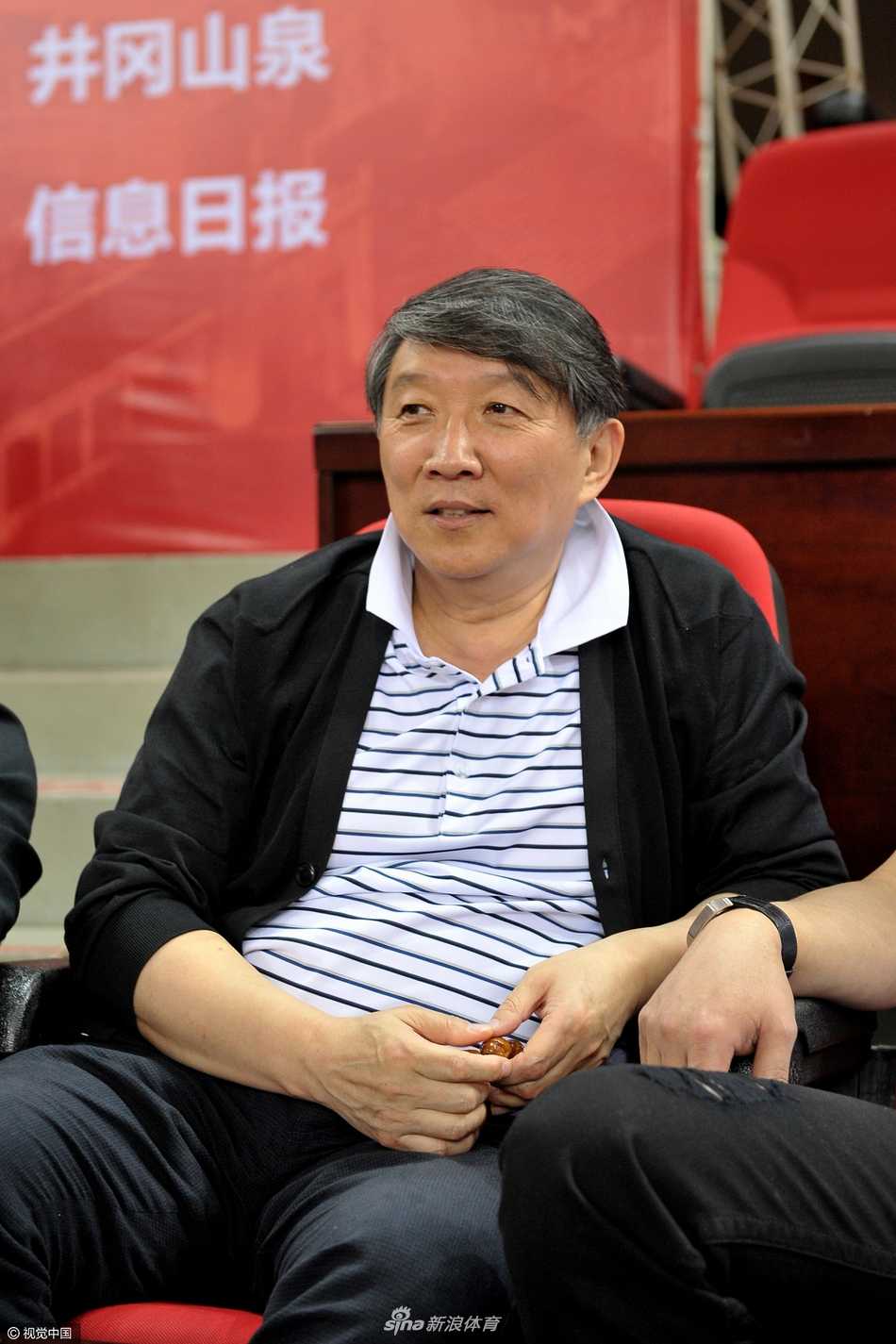 宫鲁鸣笑容满面地与身边人交谈，眼神中透露出对后辈的关切与欣慰。赛场上的年轻人，或许正是中国篮球未来的希望。