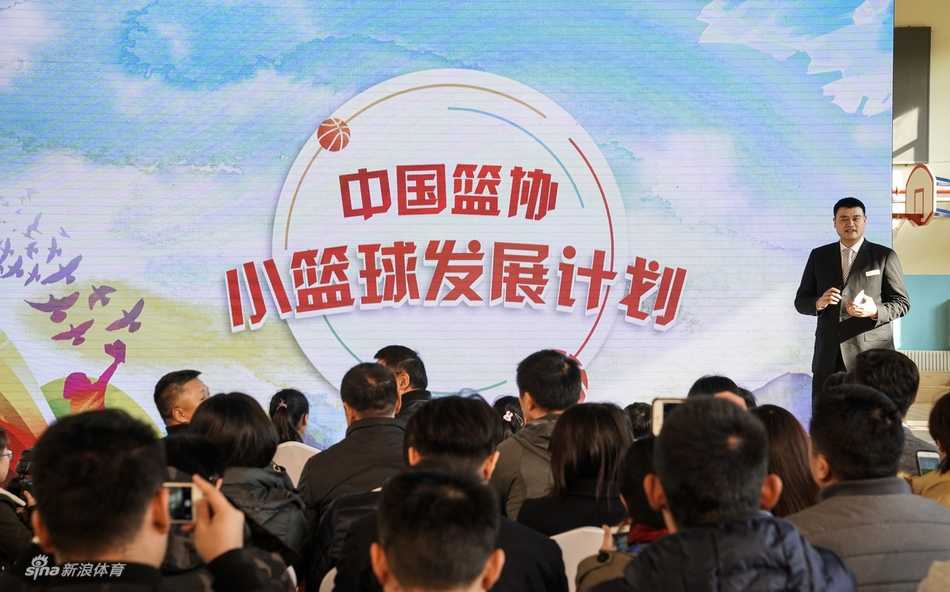 小篮球,大梦想:姚明启动中国少年篮球新篇章 几位领导嘉宾站在摆满捐赠小篮球和篮架的桌子后,准备将这些为孩子们量身定做的体育器材送到学校手中。