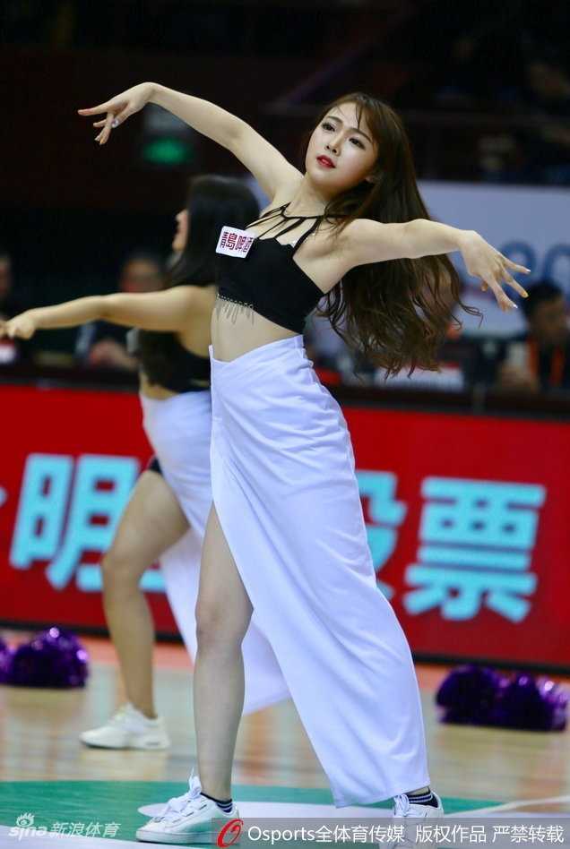 女孩扎着双马尾，身穿格子短裙搭配白色长袜，在篮球架下摆出俏皮可爱的姿势