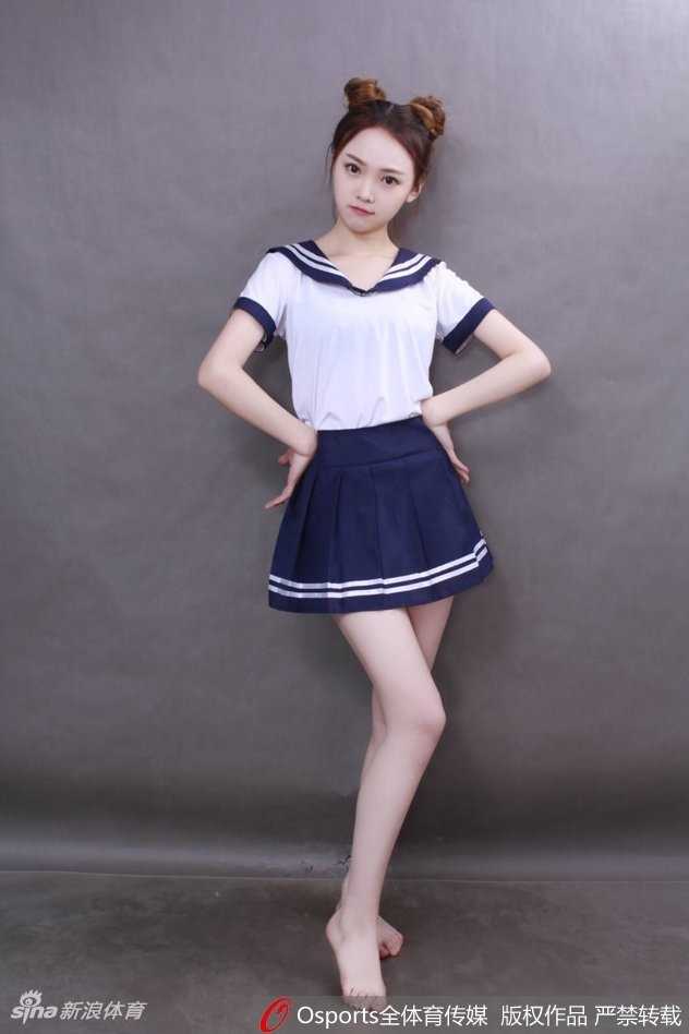 女孩身穿校园风毛衣背心，在训练场馆中压腿热身，展现出舞蹈生的柔韧与专注