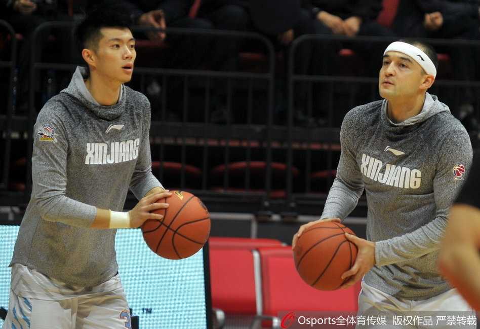 红山体育馆内灯火通明，新疆广汇队员们神情专注，正进行着赛前最后的热身跑动，篮架下映衬着卫冕冠军的坚韧与渴望。