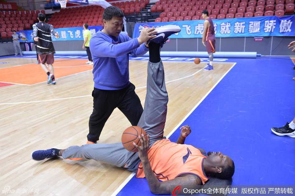 巅峰背后的汗水与温情——新疆男篮总决赛前备战纪实 灵活的胖子布莱切在体能师协助下,龇牙咧嘴地进行着韧带拉伸,表情夸张得像在表演喜剧,引得一旁的周琦忍俊不禁。