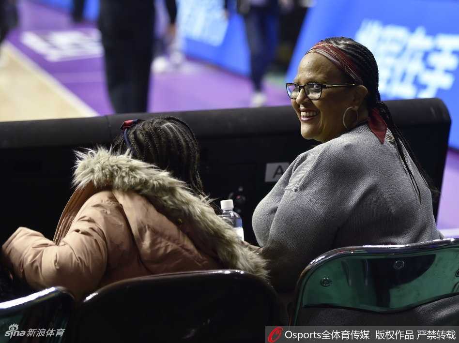 巴斯的妻子与亲友团身披辽宁队围巾，手持助威棒，脸上洋溢着骄傲的笑容，仿佛在告诉所有人：我们家的英雄正在这片球场上战斗。