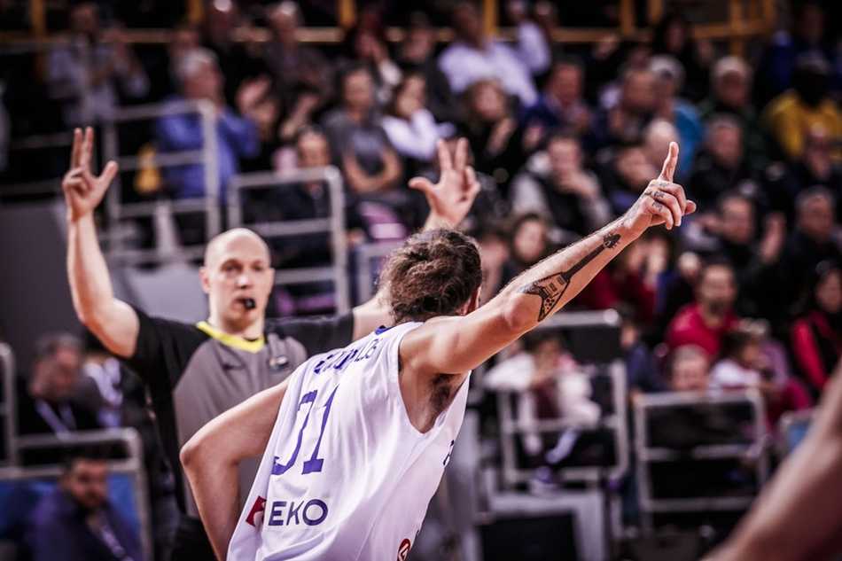 博洛西斯在高位展现大师级策应能力，他双手将球举过头顶，视线越过防守者，正寻找空切篮下的队友，准备送出一记手术刀般的传球。