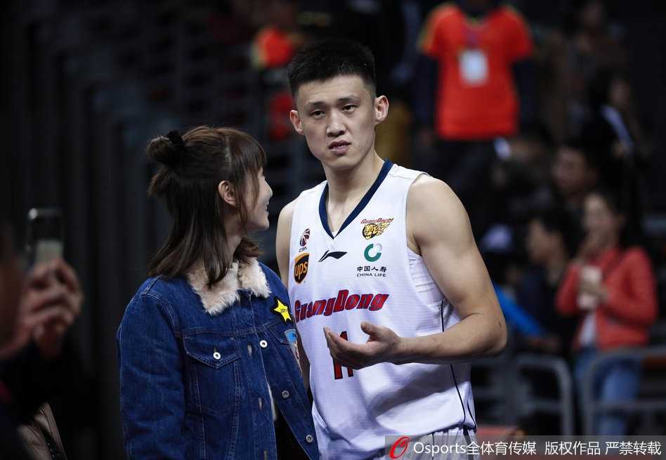 赛场边，周鹏的妻子安静地坐着，简约的穿着难掩出众气质，一双修长美腿在球场灯光下显得格外吸睛。