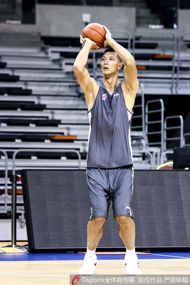 新任助教陈江华身着教练服，双手放在背后，目光如炬地注视着场上的训练情况，神情严肃而认真