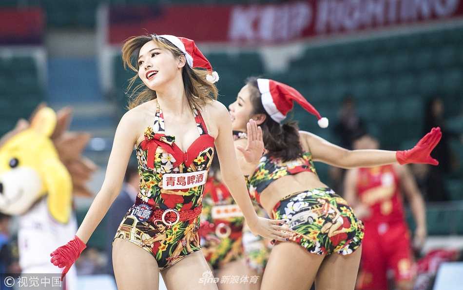 广州龙狮圣诞夜激战深圳,篮球宝贝热舞引爆全场 广州篮球宝贝们身穿圣诞红白短裙,在球场中央活力起舞,笑容灿烂。