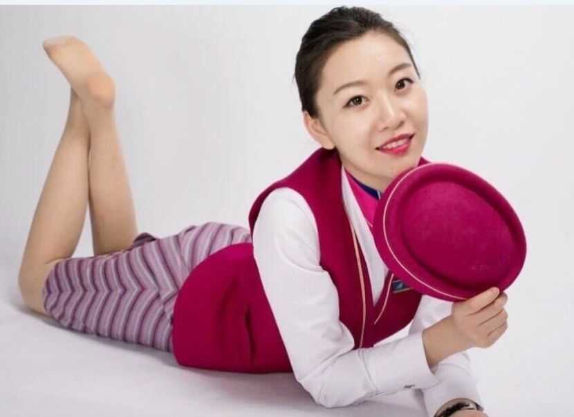 赛场边的空姐篮球宝贝侧身而立，紧身的白色运动上衣勾勒出完美身形，她专注的眼神中充满了对比赛的期待。