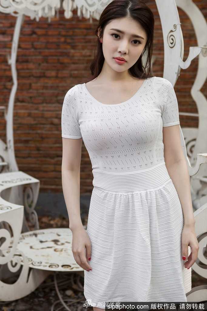徐冬冬单手轻抚秀发，白裙的蕾丝领口点缀着精致的脖颈线条，素雅的妆容衬托出她光洁的皮肤，回眸一笑间尽显东方女性的温婉大气。