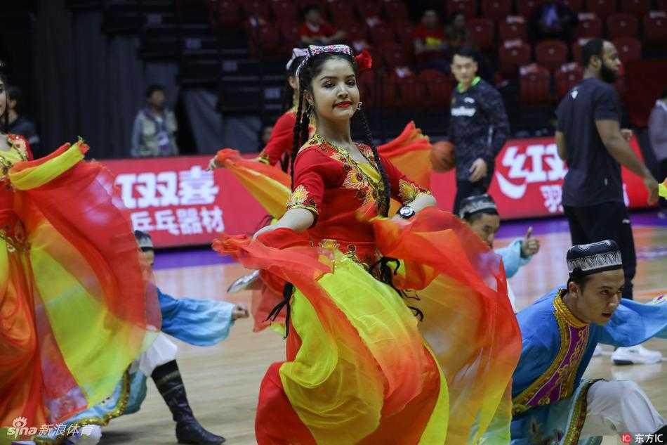 身着绚丽民族服饰的新疆啦啦宝贝在总决赛中场休息时起舞，裙摆旋转如盛开的雪莲花