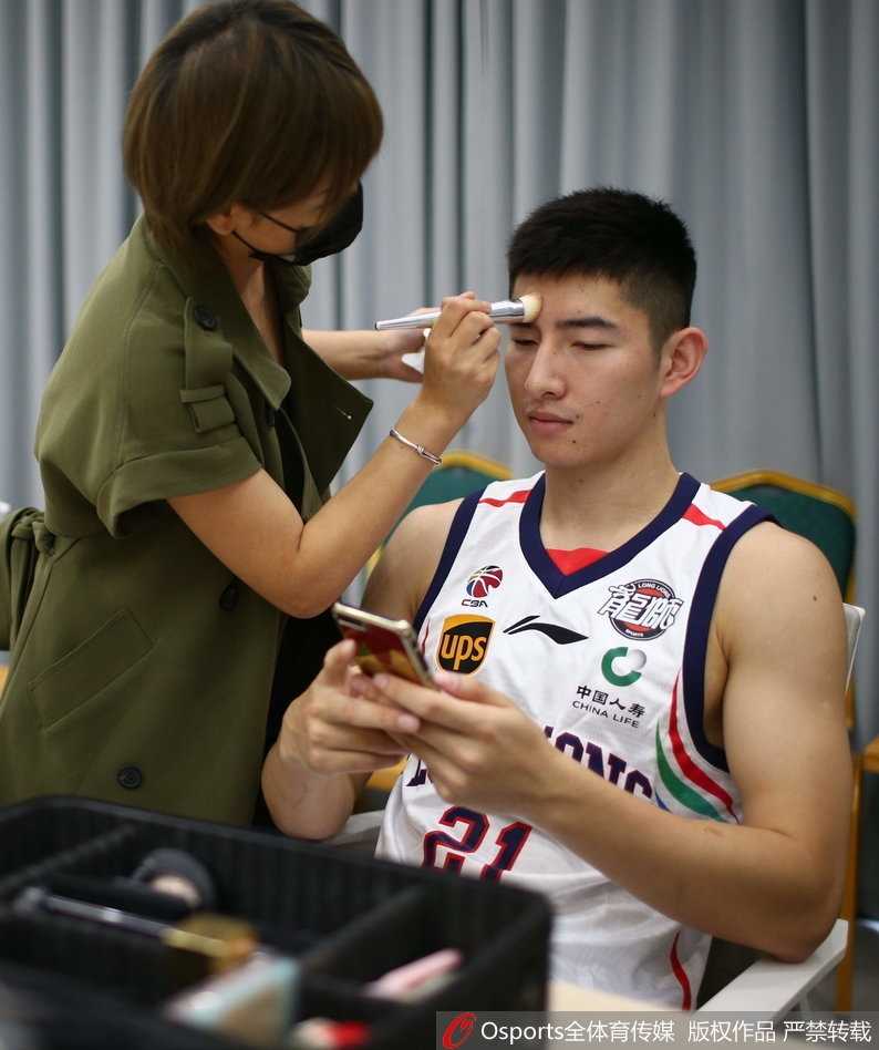 外援桑尼·萨卡基尼手持篮球，对着镜子露出标志性的笑容，他的眼神里闪烁着对即将开始的CBA赛季的无限憧憬。