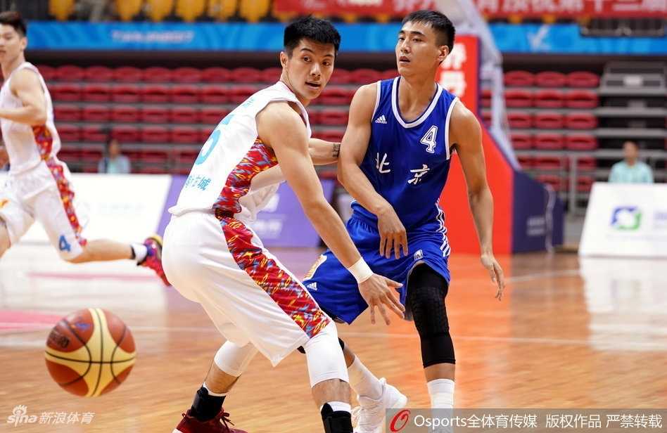 新疆队球员阿不都沙拉木在对抗中高高跃起，单手托举篮球挑篮，眼神里透着年轻人特有的锐气和坚定。