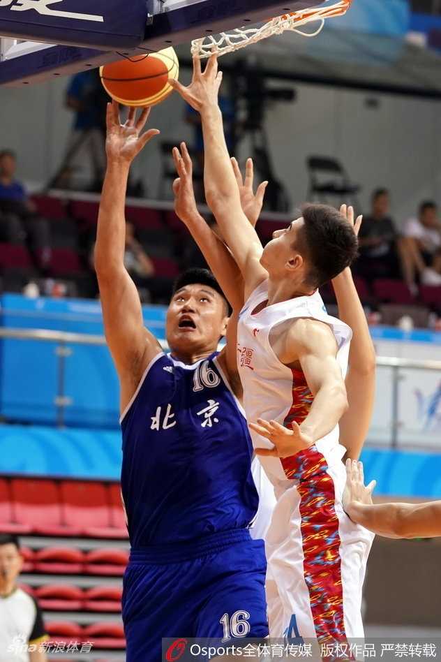 新疆球员俞长栋在篮下遭遇三人包夹，他咬紧牙关强行起篮，肌肉线条在对抗中清晰可见，展现了极强的内线统治力。