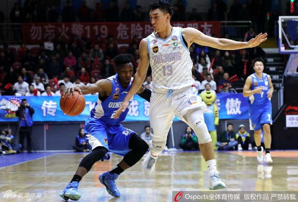 新疆队教练席前，主帅正胸有成竹地布置战术，而身后看台上的一片红色海洋，是球队最坚实的后盾。