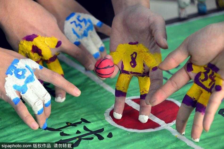 方寸指尖演绎篮球激情 聊城大学萌趣指尖比赛乐翻冬日校园 几双不同肤色的手交织在迷你球场上空,指尖上分别涂着红蓝两色。一颗小小的纸团篮球正从一根手指尖被挑起,即将飞向不远处的‘篮筐’,对手的‘防守球员’正试图拦截,画面定格在攻防转换的紧张瞬间。