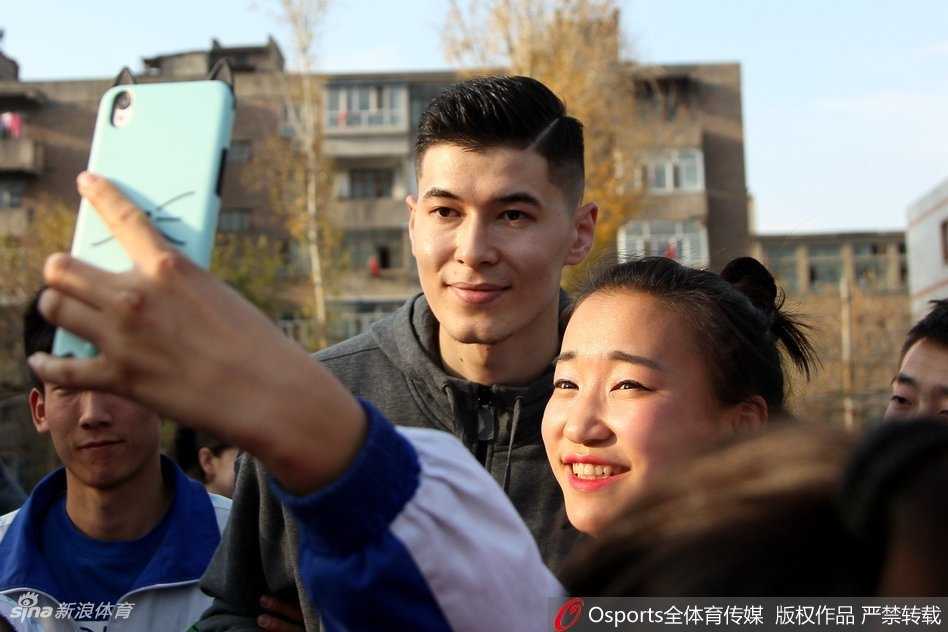 无声世界里的篮球火焰:新疆男篮与聋哑孩子的飞虎情缘 活动最后的大合影,球员们比划着刚刚从孩子们那里学到的手语姿势,所有人脸上都洋溢着快乐的笑容。这张合影记录下的不仅是友谊,更是无声世界与有声世界之间最真挚的连接。