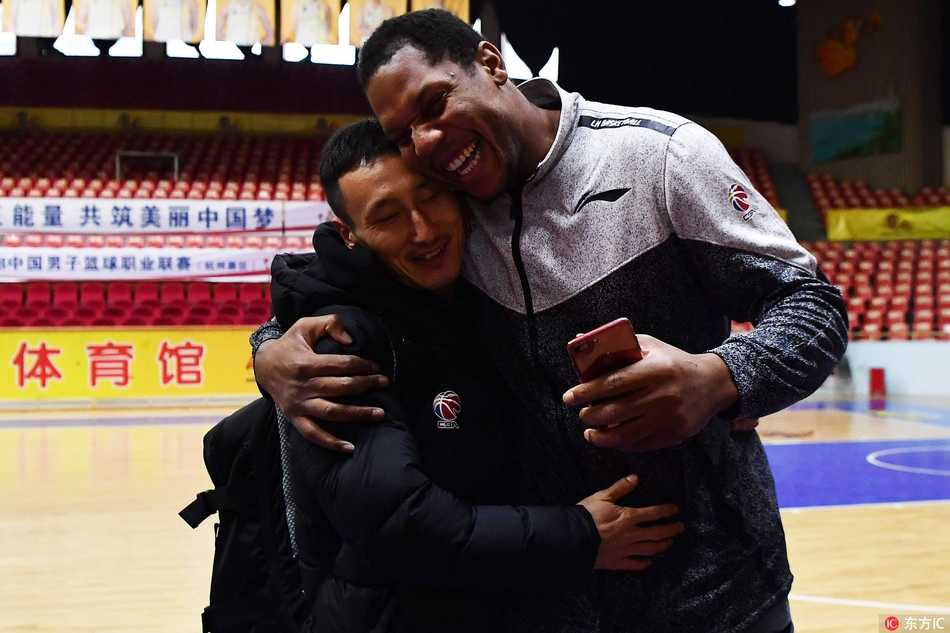 霍尔曼蹲下身与昔日队友的小孩玩耍，巨大的身躯与小孩子的稚嫩形成鲜明对比，画面温馨有爱