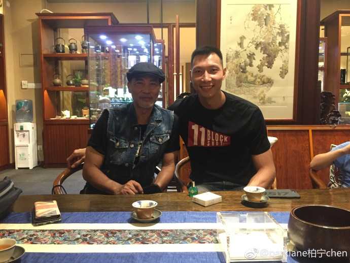 易建联与任达华:当篮球MVP遇见银幕型男 在餐厅一角,两人合影留念,阿联微微侧身照顾镜头高度,任达华则双手插袋,气定神闲,背后是都市璀璨的夜景。