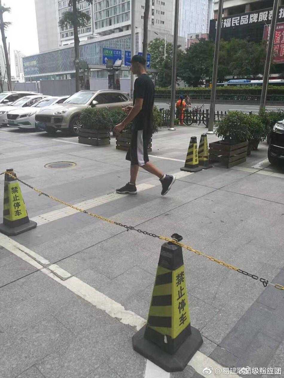 易建联夫妇街头漫步,模特妻子荆灵低调代言自家品牌 两人行走间自然地靠近彼此,荆灵侧头似在与阿联轻声交谈,阿联则微微侧耳倾听,举手投足间流露出无需言语的信任与亲昵,背景繁华的街景此刻也成了他们二人世界的温馨陪衬。