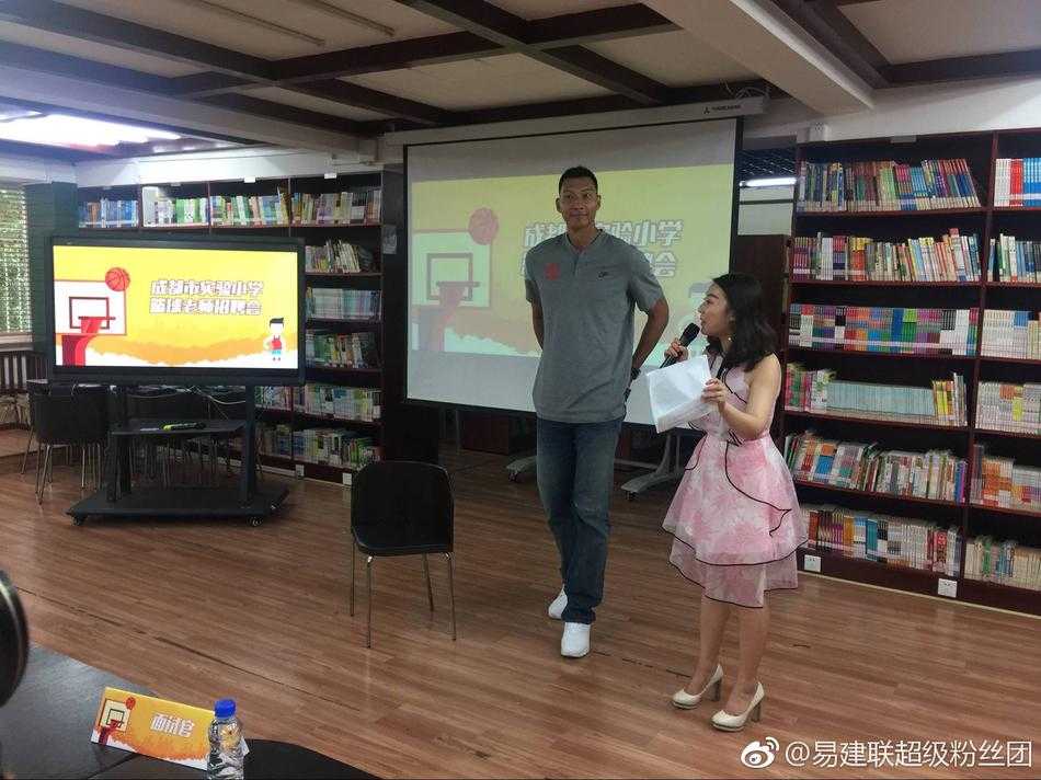 在洒满阳光的操场上，易建联正弯下他高大的身躯，耐心地指导一名小球员的运球姿势。周围围满了穿着统一校服的孩子，他们目不转睛地盯着“易老师”，眼神里满是崇拜与兴奋。