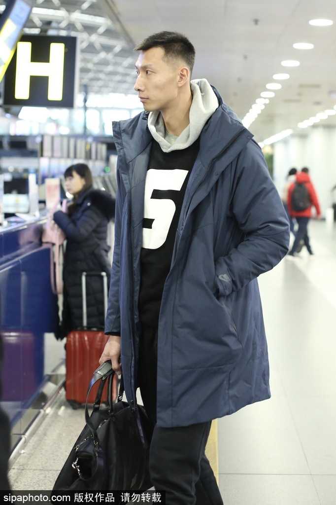 易建联戴着时尚墨镜现身机场，黑色休闲外套配潮裤，大步流星间气场全开，仿佛将机场走成了篮球赛场