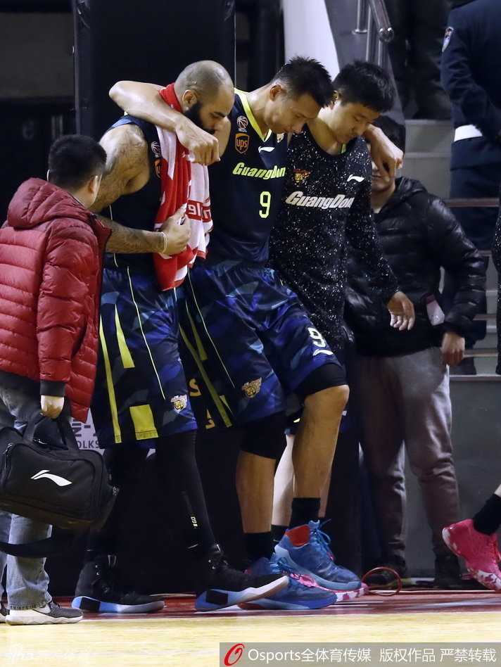 易建联在两名队友的全力搀扶下离场,他全身重量几乎都压在队友身上,低垂着头,步伐蹒跚地离开赛场
