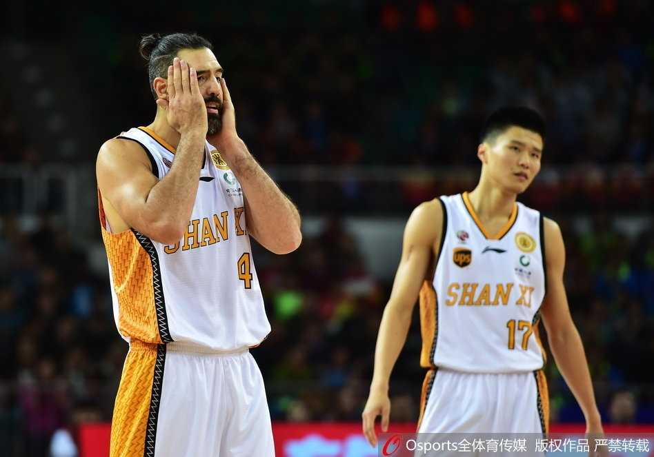 北控队兰多夫与山西队斯科拉在篮下肌肉碰撞，两人奋力拼抢篮板球，对抗激烈火花四溅。